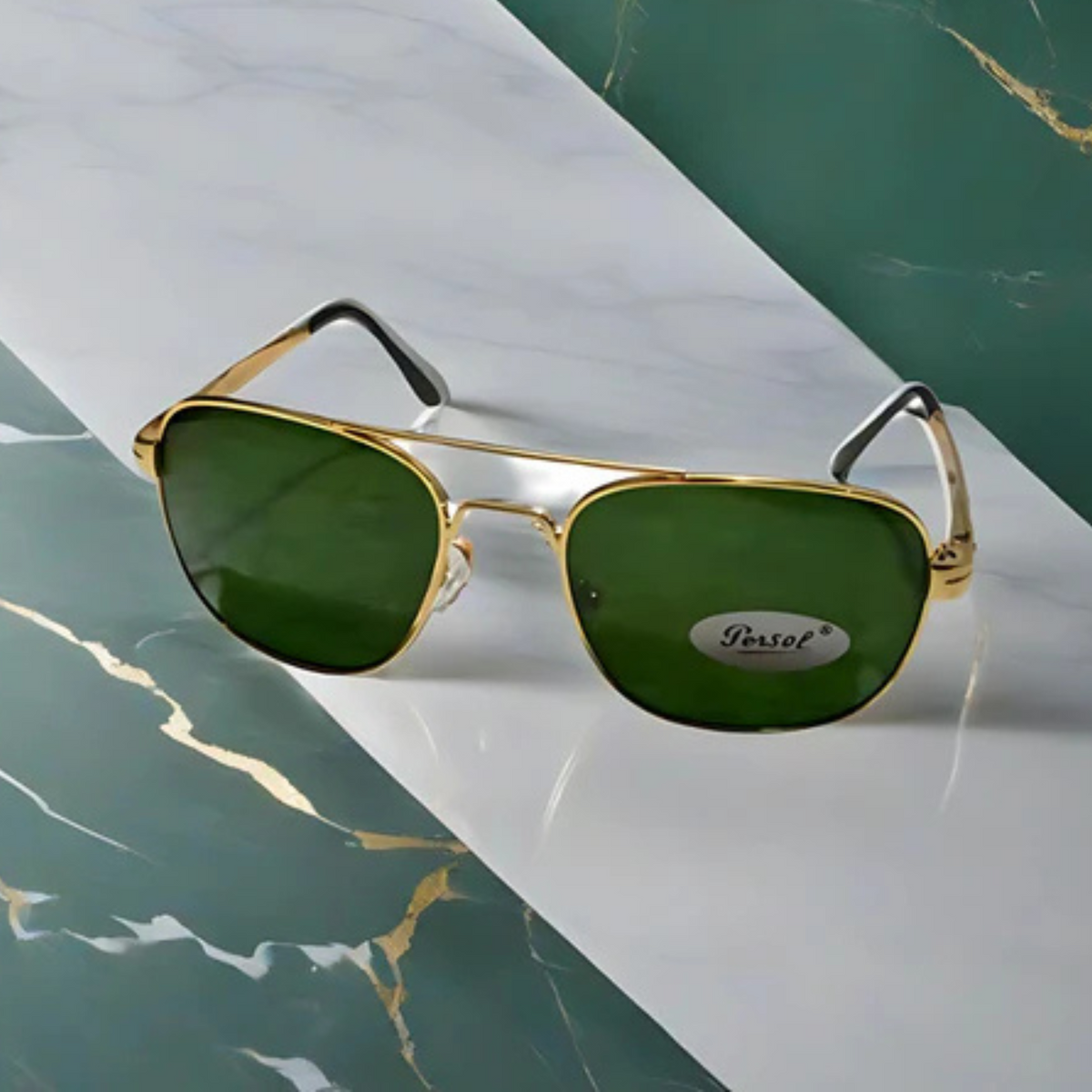 Gold-framed sunglasses with green lenses on a marble surface