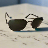 Aviator sunglasses on a pink surface with a blurred background