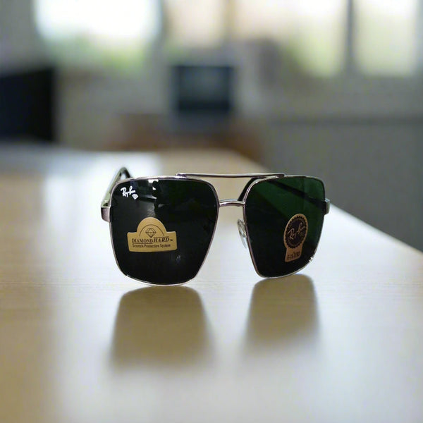 A pair of Rayban sunglasses with a square design and black frame, displayed on a table.