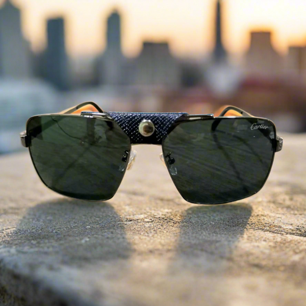 Sunglasses with a textured strap on a concrete surface with a blurred cityscape background