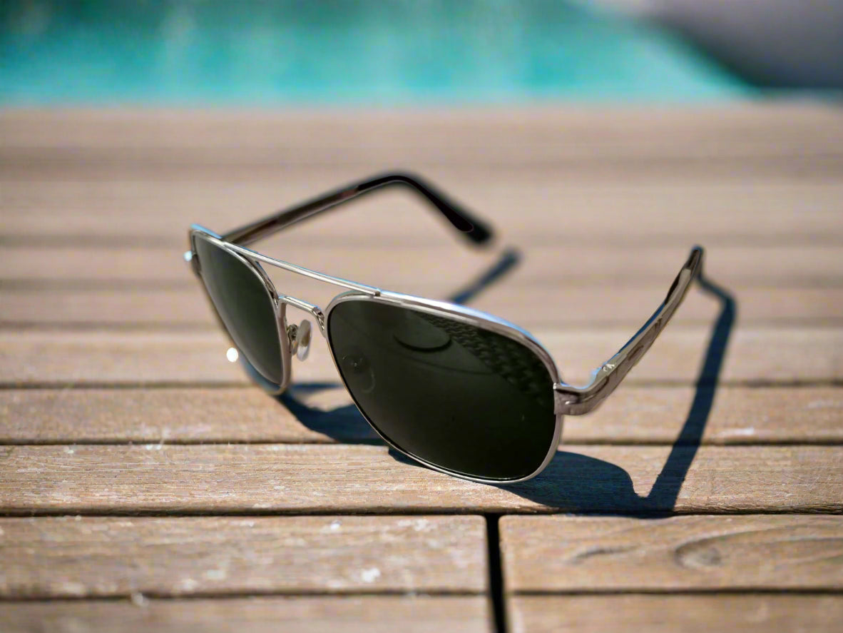 Aviator sunglasses on a textured surface with a blurred background