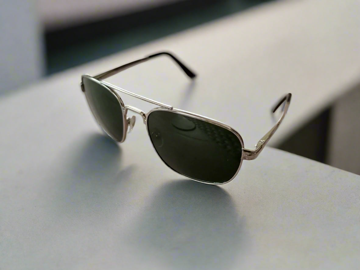 Aviator sunglasses on a textured surface with a blurred background