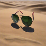 Sunglasses with green lenses and red frames on a textured surface