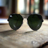 Black sunglasses with a logo on a textured surface